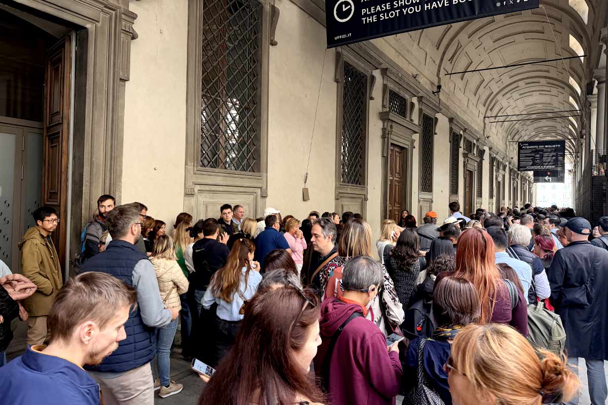 Long queue of tourists waiting to enter Uffizi Gallery Florence